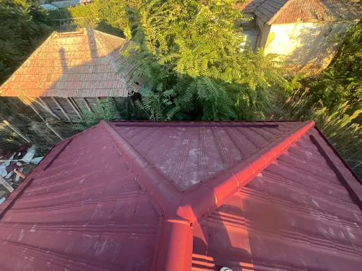 Vale de acoperiș din țiglă roșu-vișinie, la apus, lumină portocalie puternică