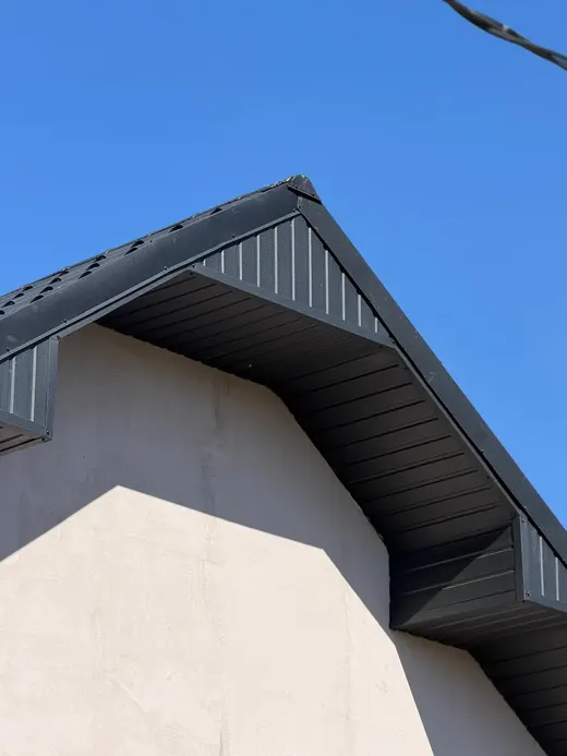 Detaliu vârf de fronton, tablă neagră, perete bej