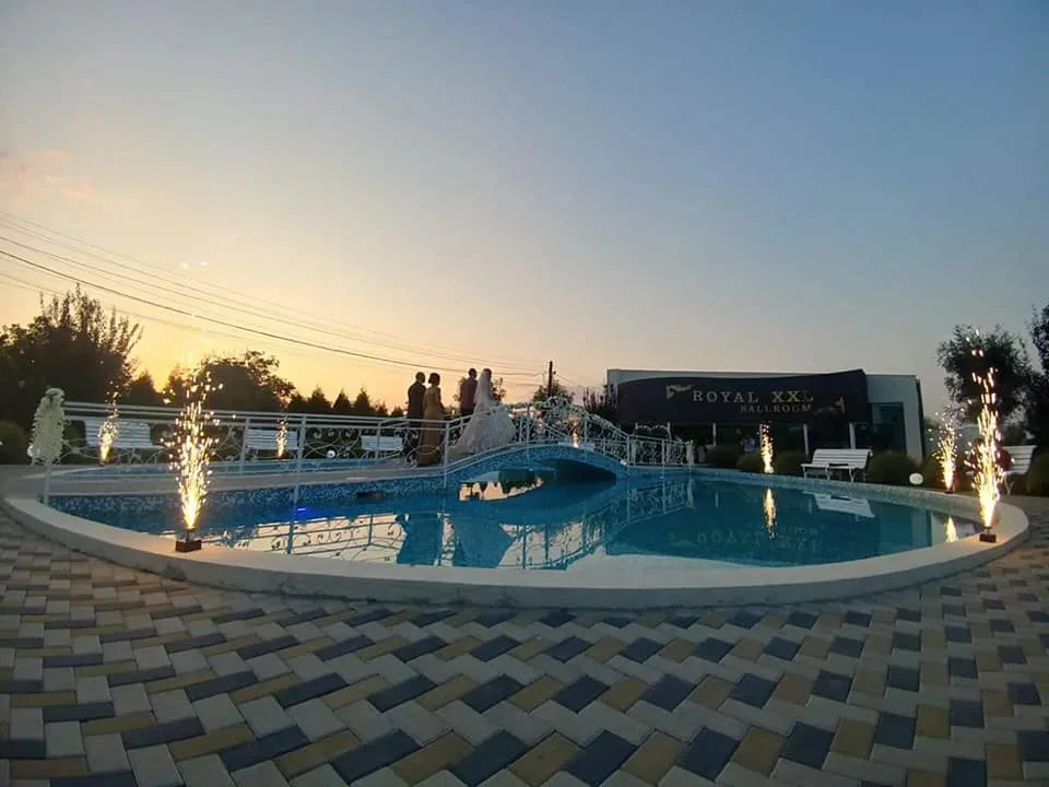 Curtea Royal XXL la apus: piscina, clădirea și jerbele de artificii