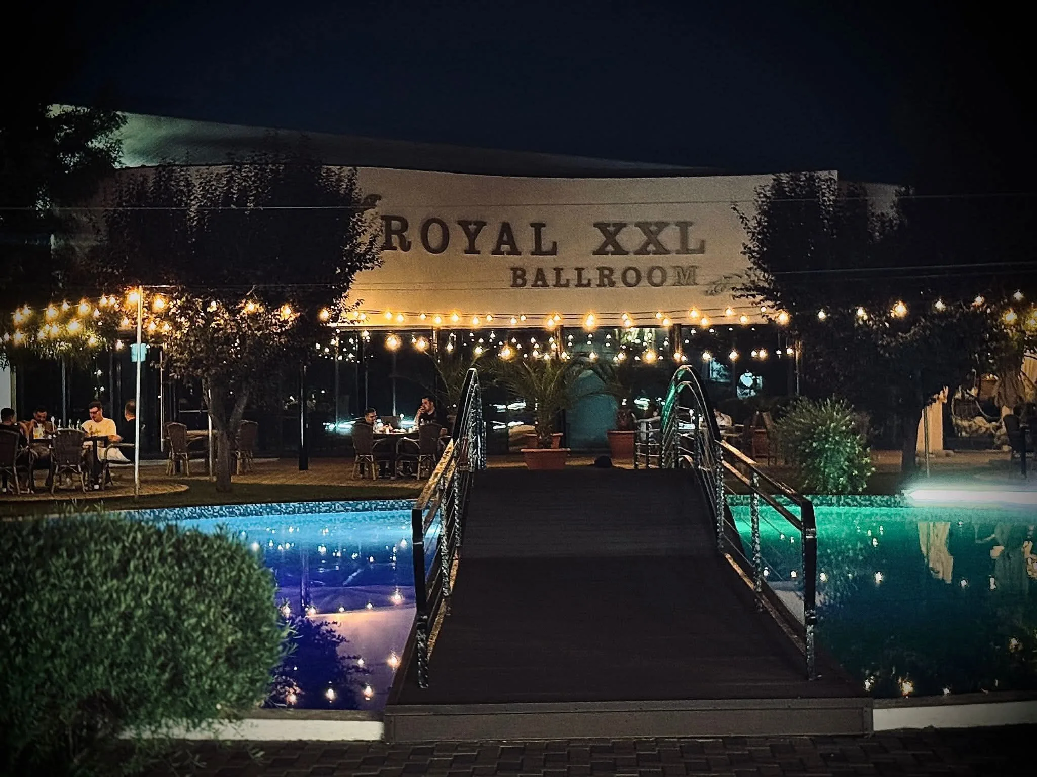 Firma luminată noaptea și piscina cu lumini colorate