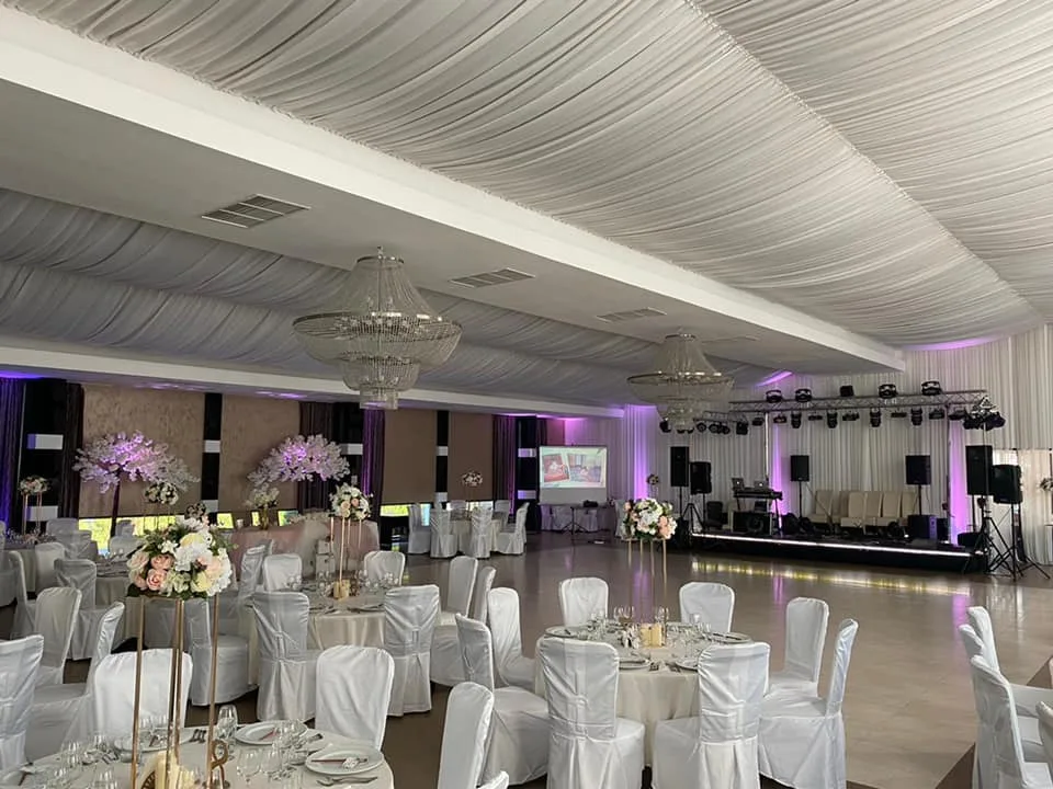 Sala mare cu mese aranjate și lumini roz
